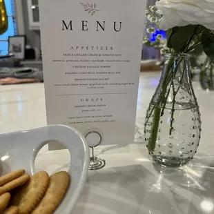 a table setting with a menu and flowers