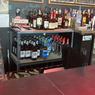 liquor bottles on shelves and menus on the wall