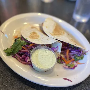 a plate of tacos with a side of coleslaw slaw