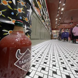 a bottle of sauce on a tiled floor