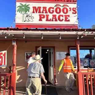 two men standing outside of a restaurant