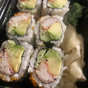 a tray of sushi with avocado