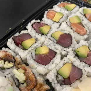 a tray of sushi with avocado