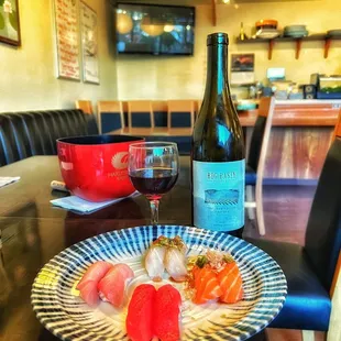 a plate of sushi and a glass of wine