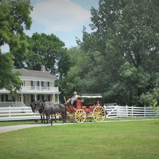 The mudwagon style stagecoach rests in front of the 1865 limestone Mahaffie home.