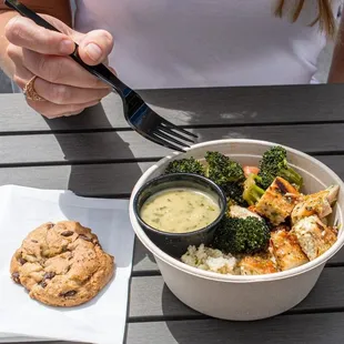 A bowl and a chocolate chip cookie