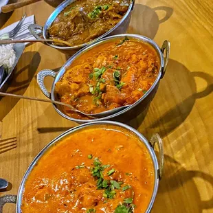 a variety of indian food on a wooden table