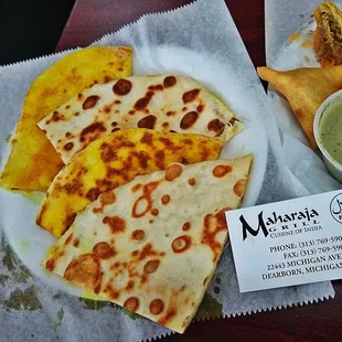 a plate of quesadillas and a bowl of dip