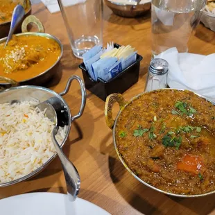 Bengan Bartha (Eggplant Curry) in front, chicken korma in the middle, and chicken tikka masala at the back. Garlic naan at the top right.