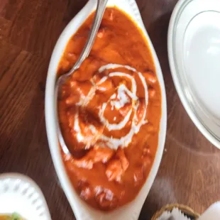 a bowl of tomato soup with a spoon in it