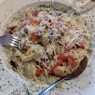 Chicken sauteed with artichoke and tomatoes over angel hair pasta