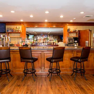 a bar with stools and a television