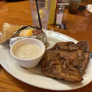 Chicken fried steak dinner with a loaded baked potato