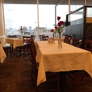 a table with a vase of red roses