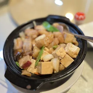 tofu in a black bowl with chopsticks