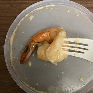 a plate of shrimp and sauce with a fork