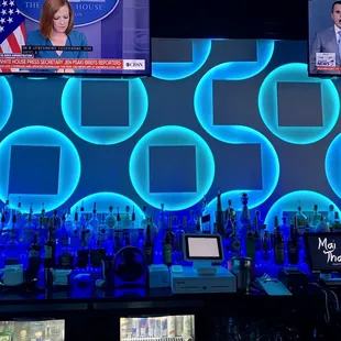 a bar with a television screen and blue lights