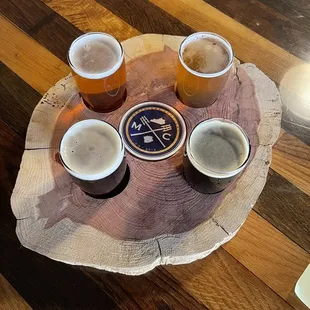 a variety of beers on a wooden tray