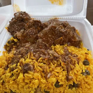 Beef chunks in red sauce with yellow rice mixed with sausage and beans