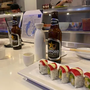 a bottle of beer and a plate of sushi