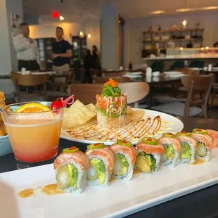 a plate of sushi and a glass of orange juice