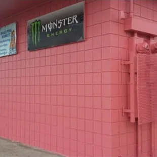 a pink building with a sign that says monster energy