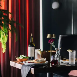 a dining table with a bottle of wine and a plate of food