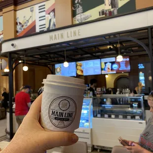 a hand holding a cup of coffee