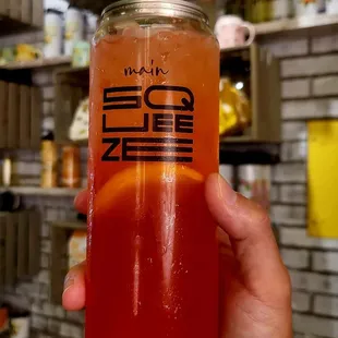 a person holding a jar of juice