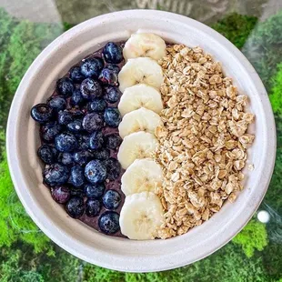 a bowl of oatmeal with bananas and blueberries