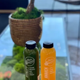two bottles of juice on a glass table