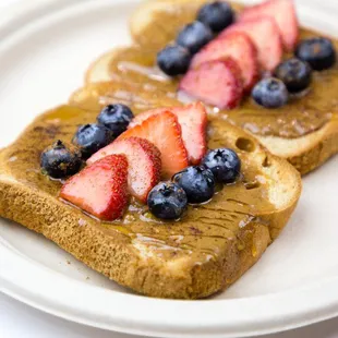 two pieces of toast with strawberries and blueberries