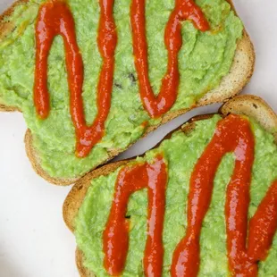 two slices of bread with guacamole and ketchup