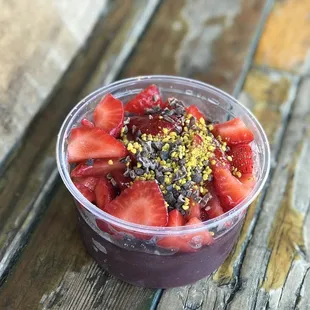 strawberries in a plastic cup on a wooden table