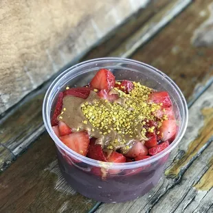 strawberries in a plastic cup on a wooden table