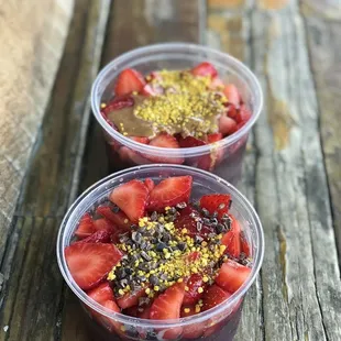 two bowls of fruit on a wooden table