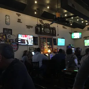 people sitting at tables watching tvs