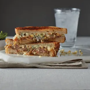 ows a grilled cheese sandwich and a glass of water