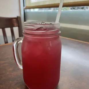 a jar of red liquid with a spoon in it