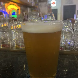 a glass of beer on a bar counter