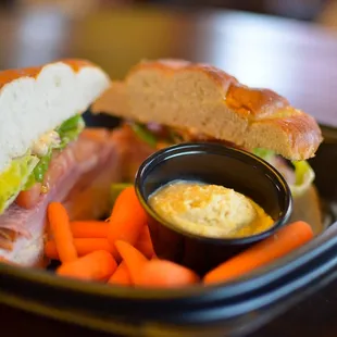 Elwood sandwich on pretzel bun with carrots and hummus