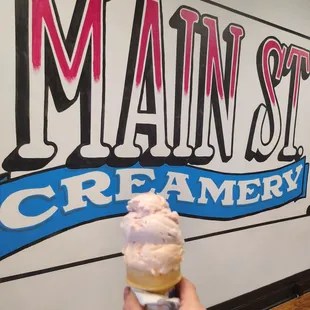 a hand holding an ice cream cone