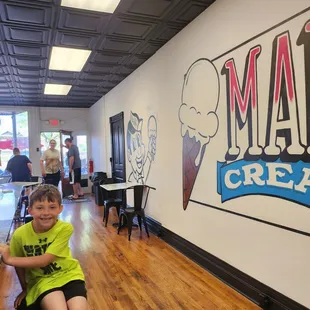 a young boy sitting on a stool
