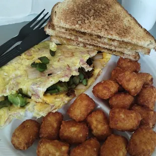 Western omelet with wheat toast and tots .
