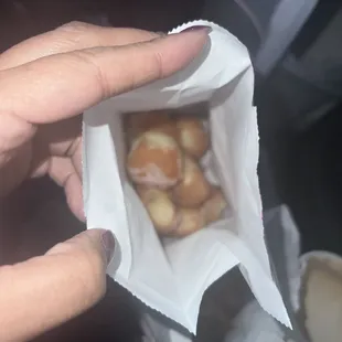 a person holding a bag of doughnuts