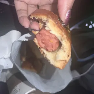 a hand holding a half eaten donut