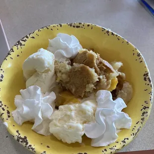 Awesome homemade peach cobbler with vanilla ice cream and whip cream