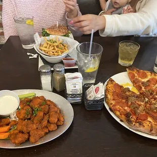two people eating pizza and fries