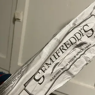 a hand holding a bag of groceries