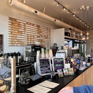 a coffee shop counter with a variety of coffees